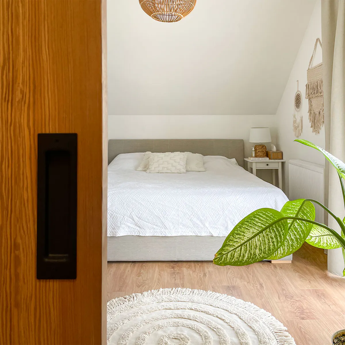 lit rembourré gris sous plafond incliné dans la chambre