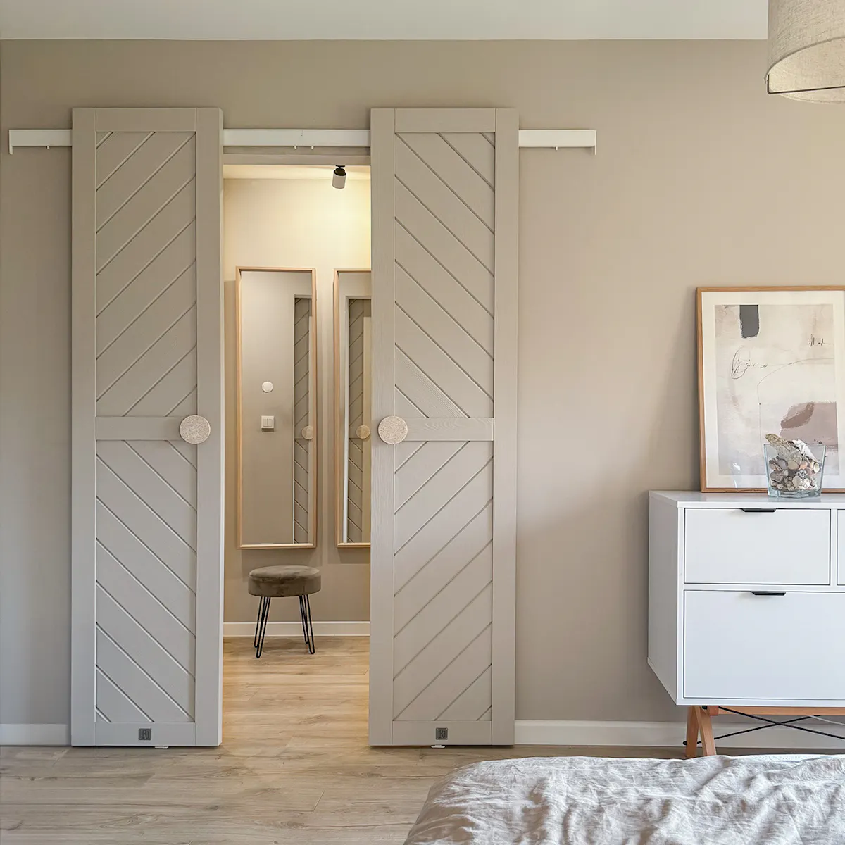 Open double sliding doors to walk-in closet in minimalist bedroom
