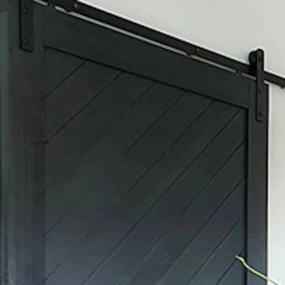 Wall collage with graphics, black sliding doors, wooden cabinet with metal legs