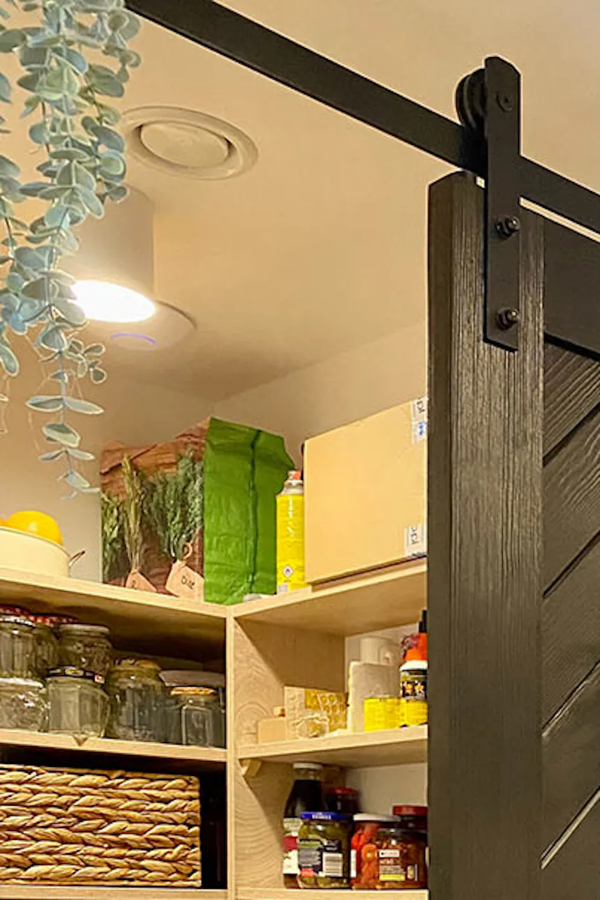 Open pantry door, black solid wood sliding door, decorative wreath on door