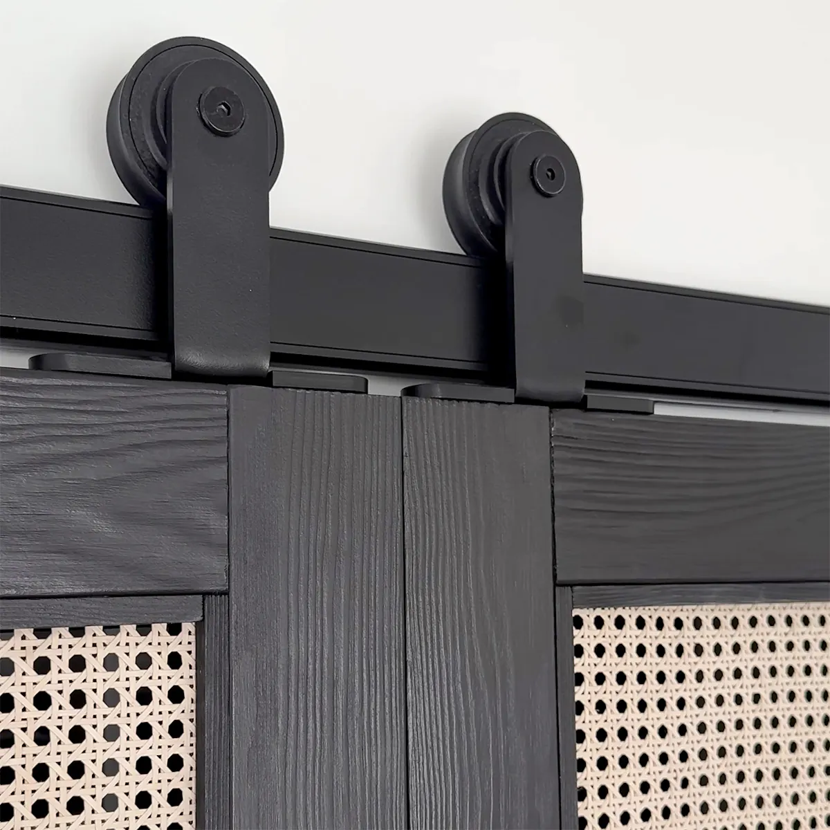 Close-up of black sliding doors with rattan panels and black sliding system