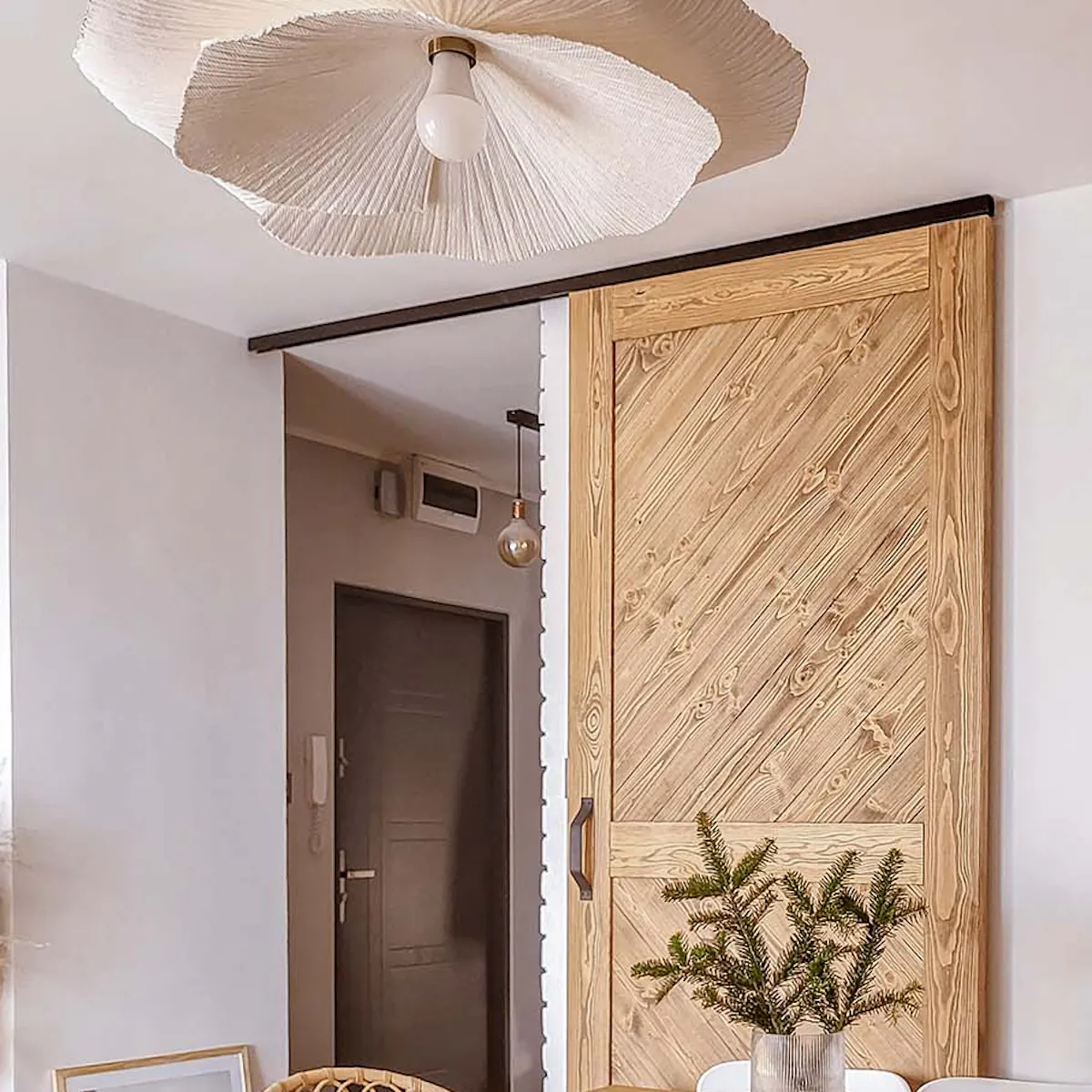 table à manger et portes coulissantes en bois sur fond de mur blanc dans le salon