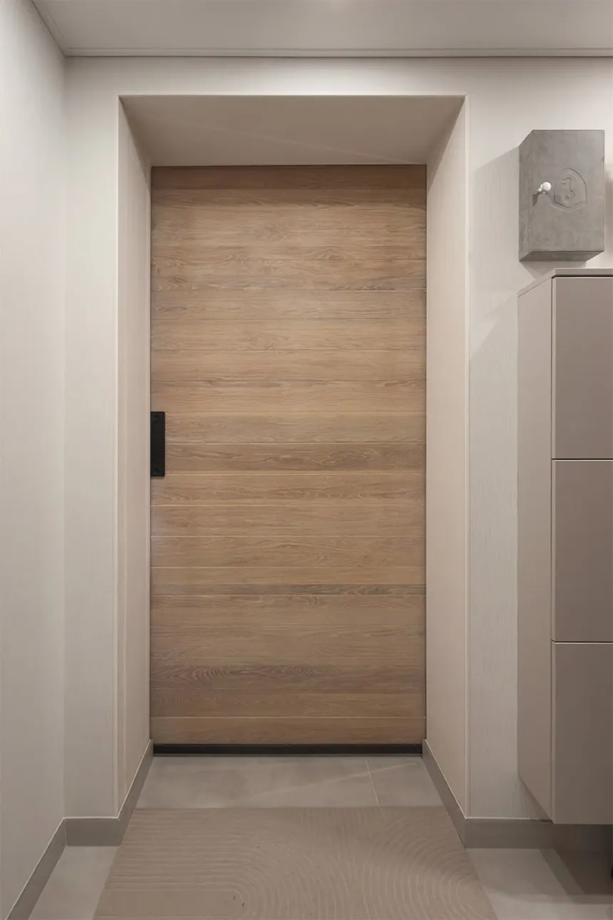 A whitewashed oak sliding door installed in the opening of a modern hallway.