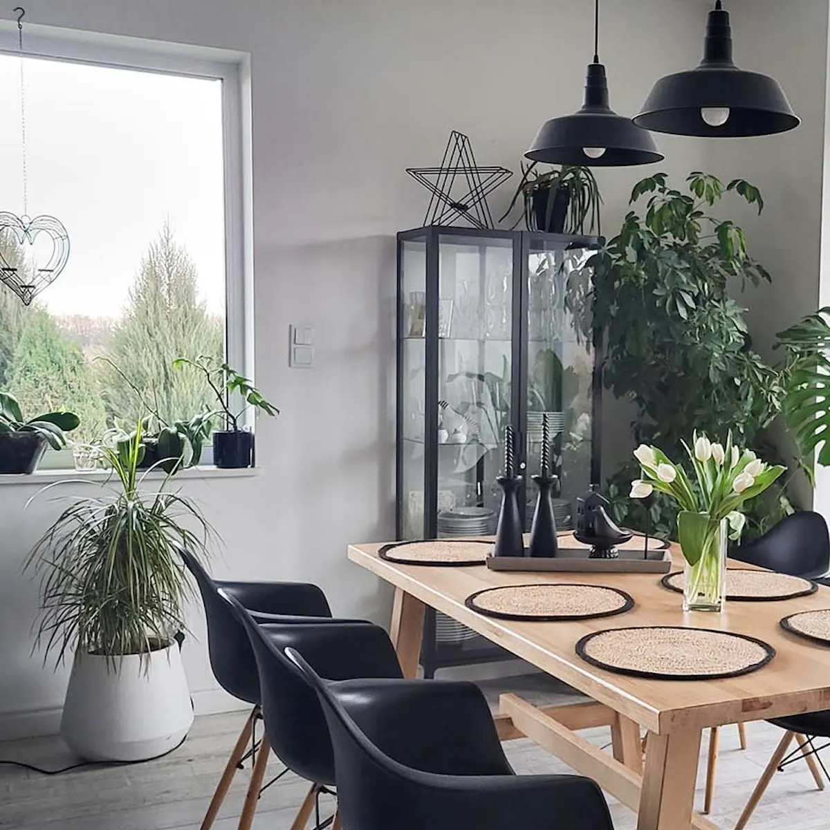 grande table à manger en bois avec chaises noires dans la salle à manger d'un salon moderne