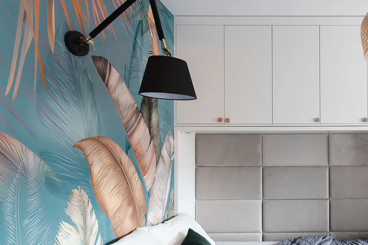 un lit caché dans l'armoire et du papier peint coloré au mur dans une petite chambre