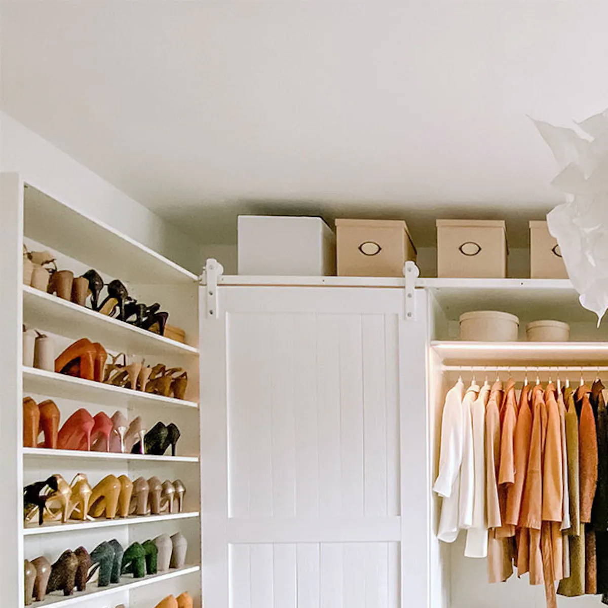 large bright walk-in closet, sliding doors in walk-in closet, large white wooden doors, white doors on white sliding system, large white closets in dressing room