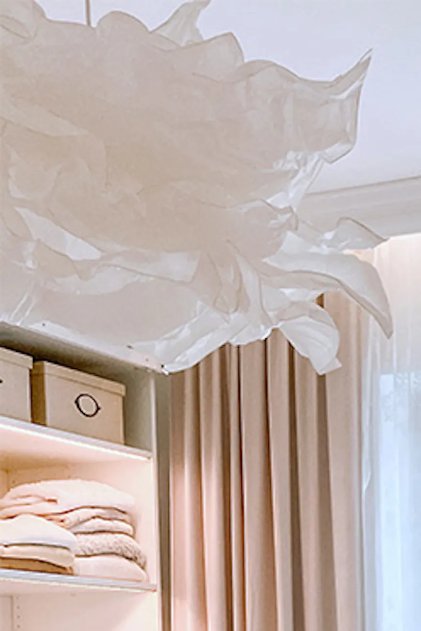 white pouf and grey sofa in dressing room, large bright dressing room, white hanging lamp, bright walk-in closet, pendant paper lampshade