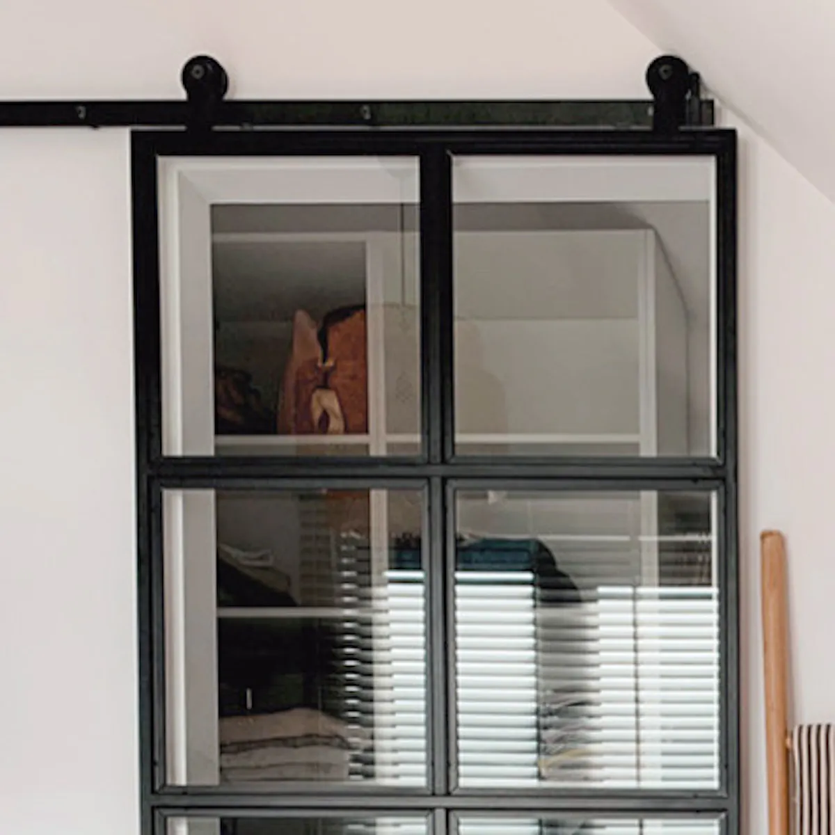chambre mansardée avec une petite dressing cachée derrière des portes coulissantes en verre