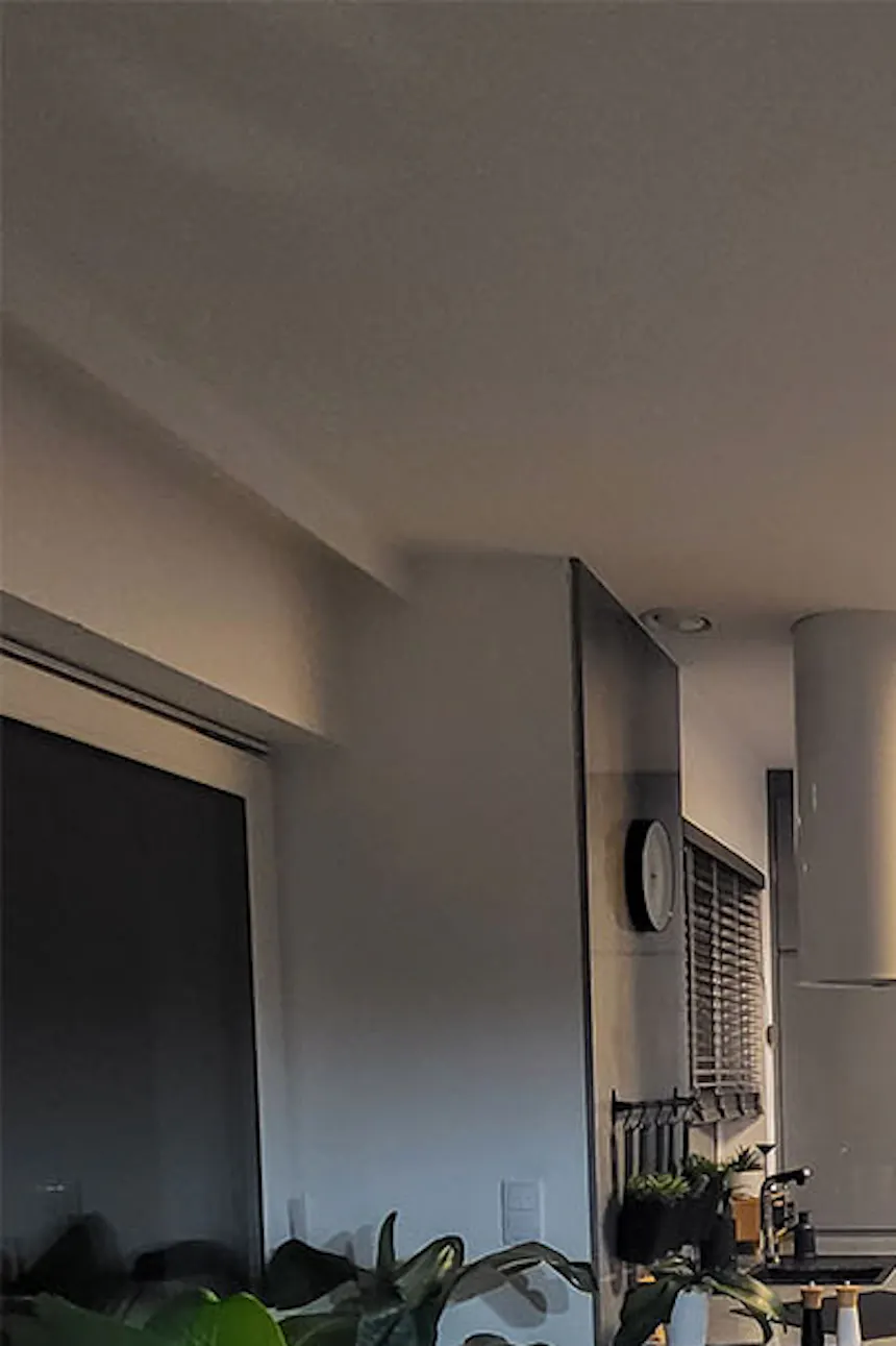 une cuisine moderne associée à une salle à manger décorée dans des tons gris avec des accessoires noirs
