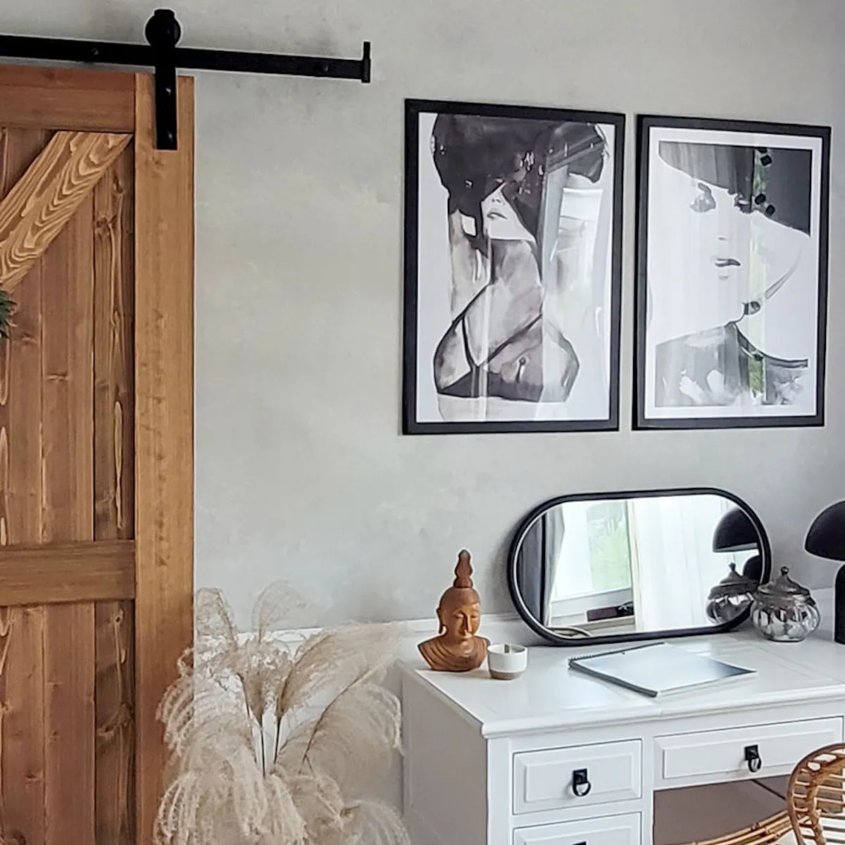 affiches en noir et blanc au-dessus d'une coiffeuse blanche avec un miroir