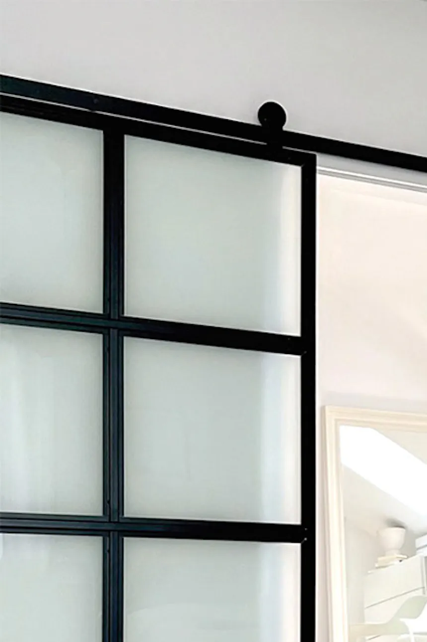 Metal glass door to a dressing room next to the attic bedroom