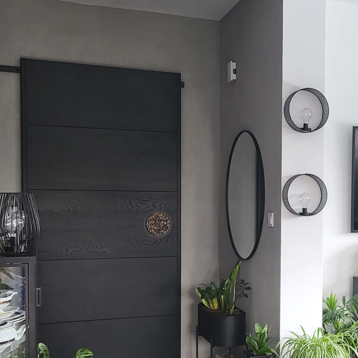 black sliding doors in a modern living room decorated in gray colors with black accessories
