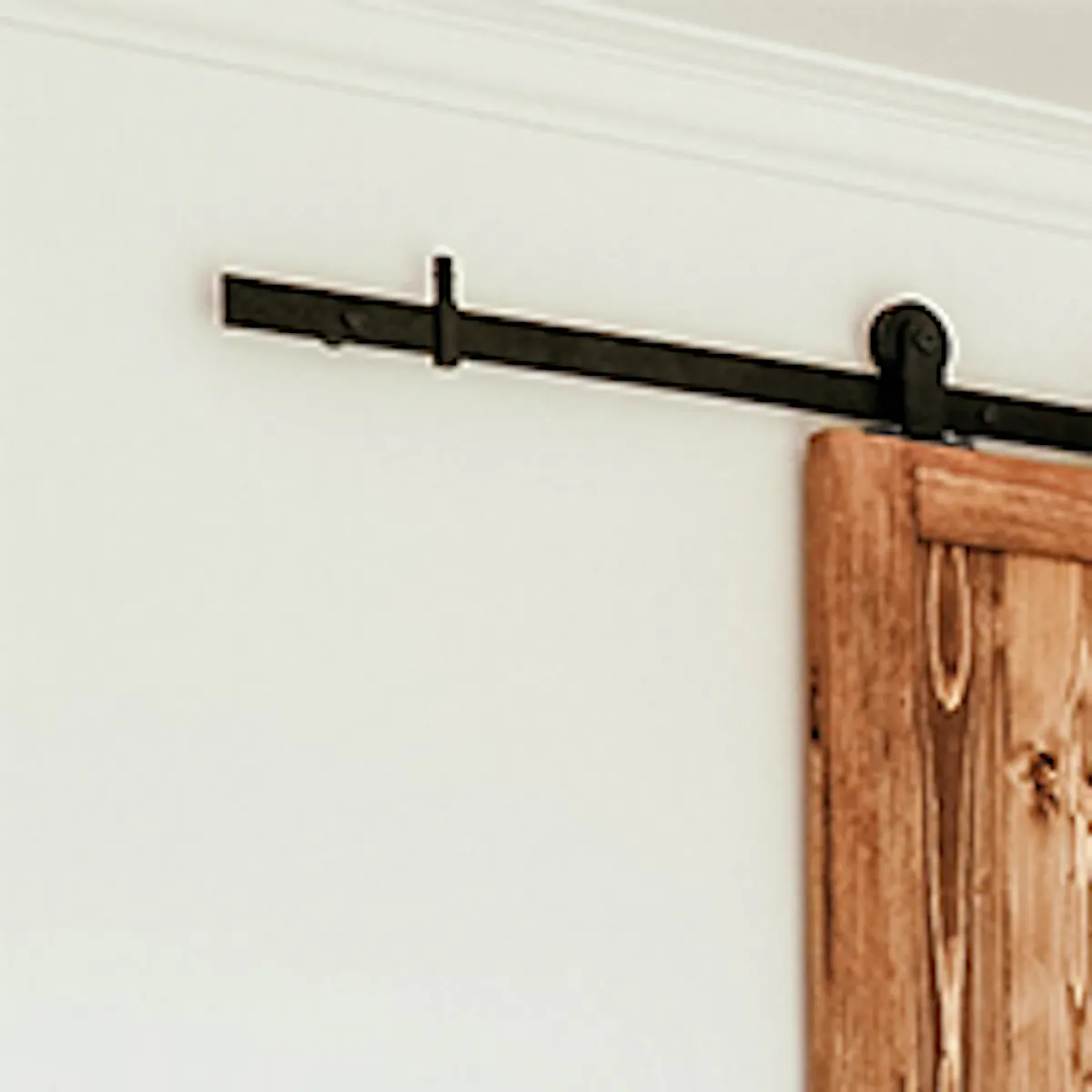 portes coulissantes étroites en bois menant au dressing de la chambre décorée dans des couleurs naturelles de blanc et de beige