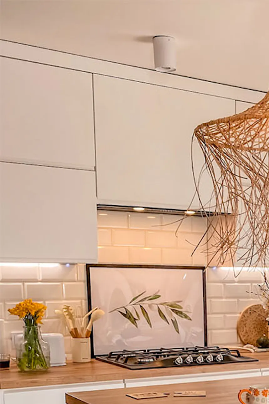 un îlot dans une cuisine blanche décorée dans un style bohème scandinave
