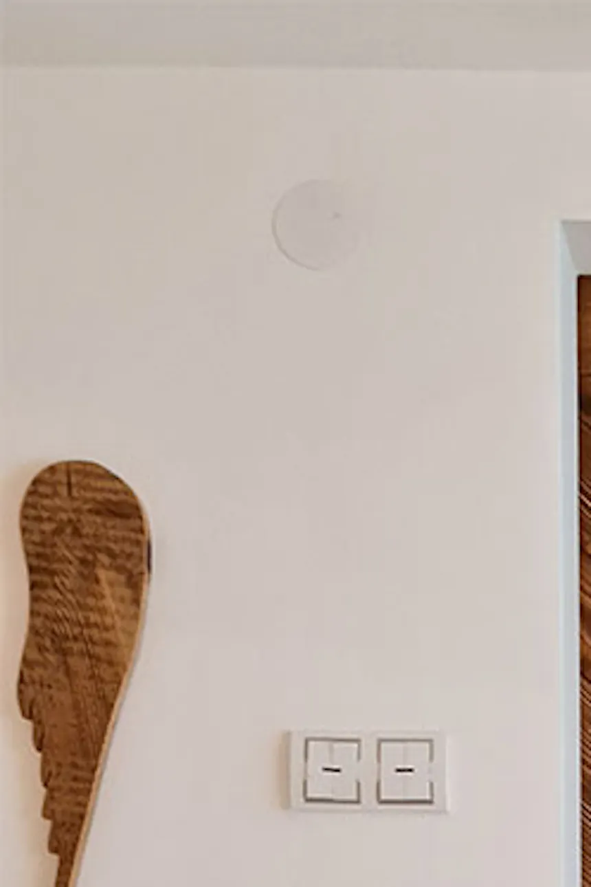 wooden sliding doors closing the entrance to the bedroom in a Scandinavian interior, flower decorations in a wicker basket, white walls in the interior