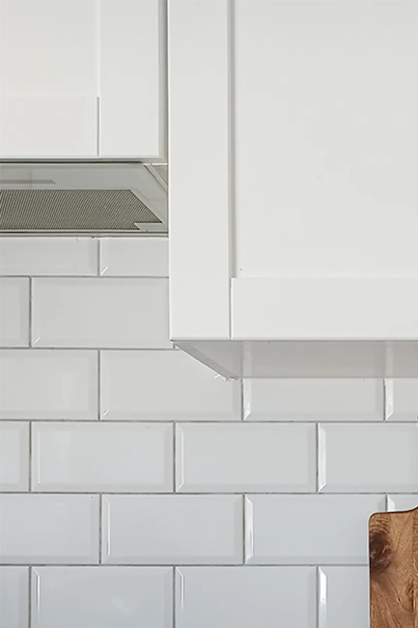 white furniture, white tiles, wooden countertop in a modern kitchen