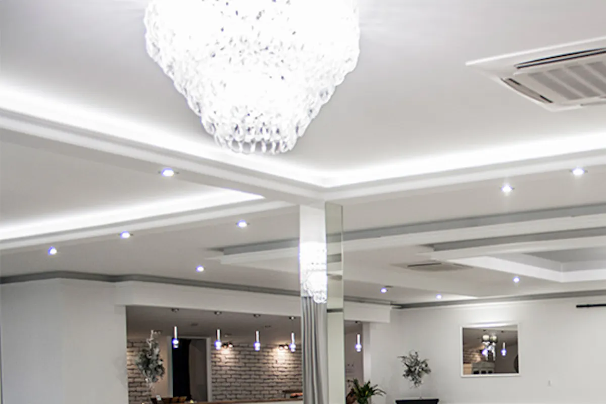 white sliding doors, decorative mirrors, a large crystal chandelier, large sliding doors, sliding glass doors, white wooden doors with glass, entrance to the ballroom