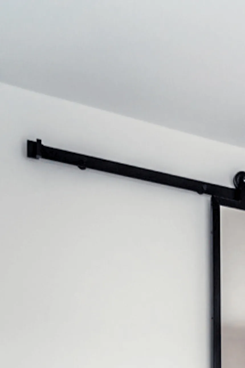 Sliding door with mirror in black metal frame in bedroom