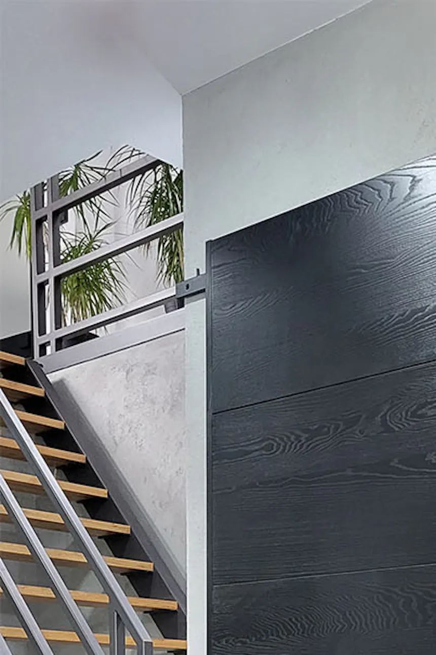 porte coulissante noire minimaliste avec poignée design dans le hall d'une maison moderne