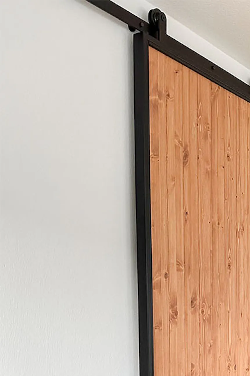 murs blancs, parquet et portes coulissantes dans le salon