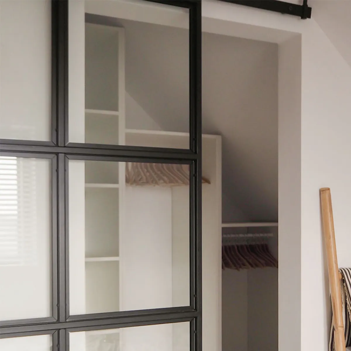 porte style loft avec du verre dans un cadre en métal fermant la dressing dans une petite chambre mansardée