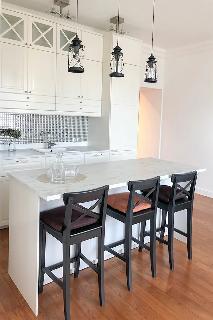 White kitchen with black accessories, industrial hanging lamps, stylized kitchen furniture, white kitchen furniture