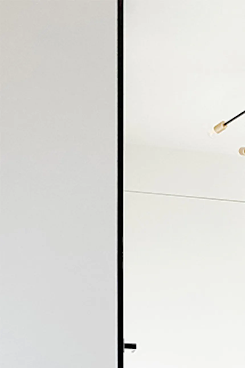 Mirror door in entryway, wooden door, microcement floor, black minimalist table in foyer, white and black entryway
