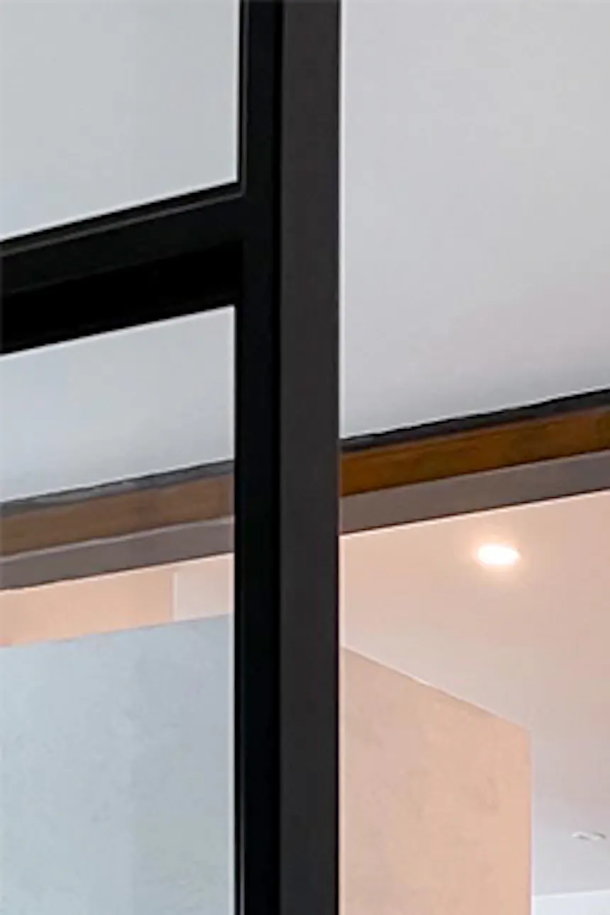 White walls, light marble flooring, open living space, black metal accessories in modern interior.