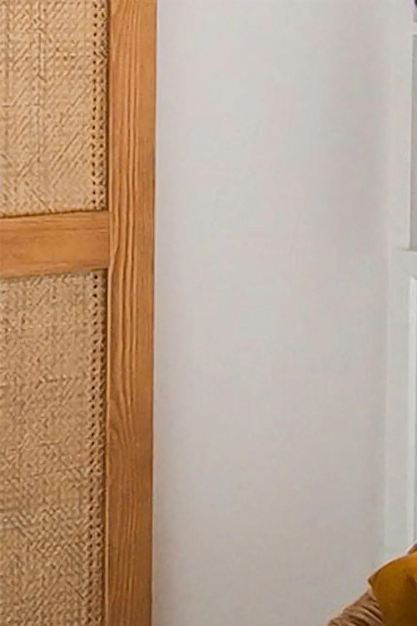 un oreiller à lettres et un fauteuil en osier dans la chambre d'une fille