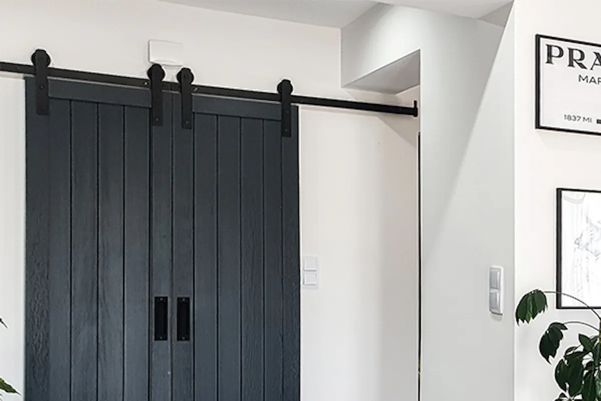 Entryway of modern home with double sliding doors, poster gallery, and openwork chairs