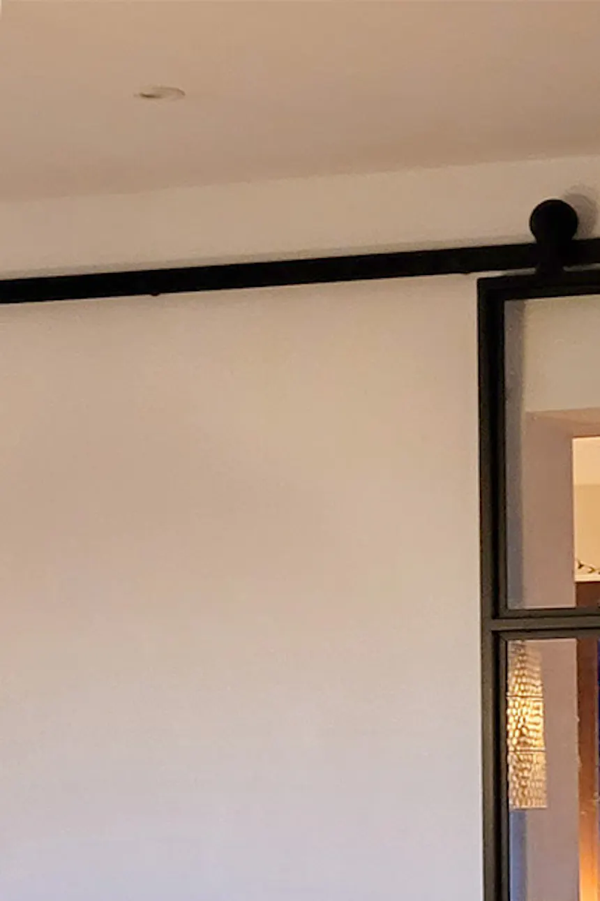 porte coulissante en verre dans un cadre en métal pour le salon