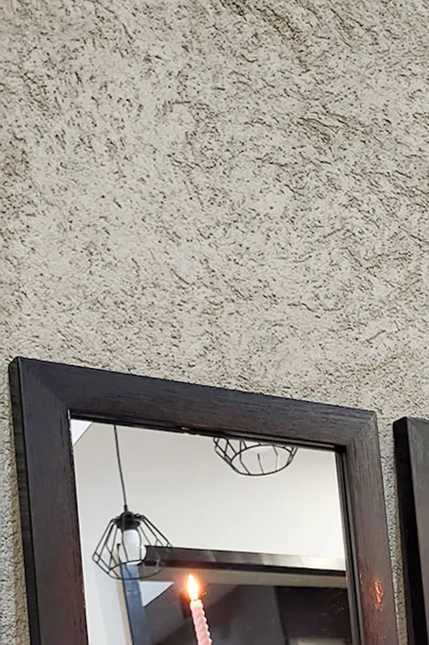 a set of small square framed mirrors above the bathtub in the bathroom