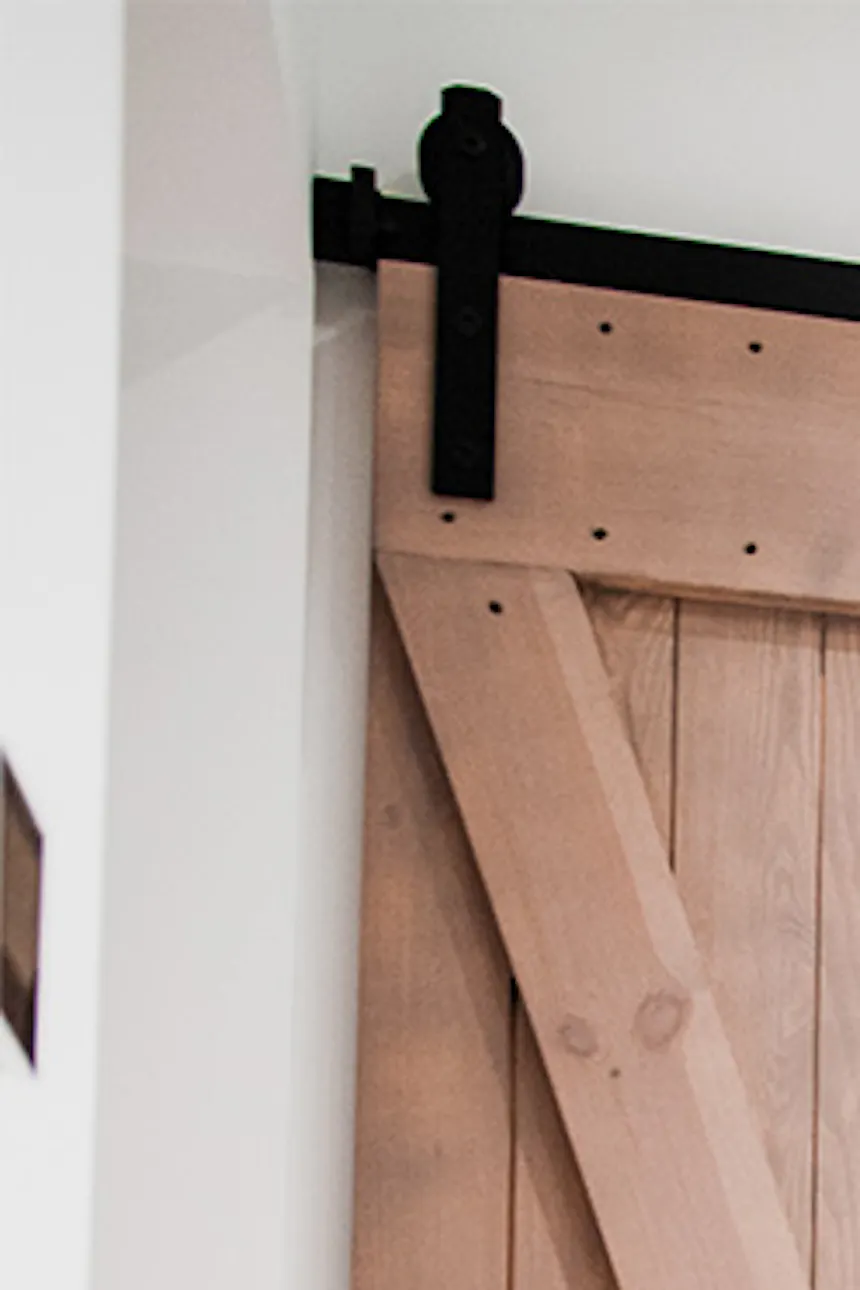 portes coulissantes en bois pour rangement dans une petite salle de bain aux murs blancs
