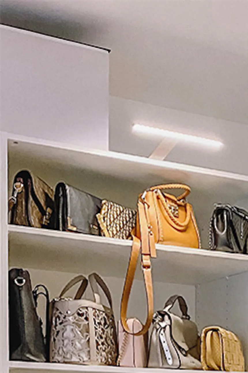 system of white shelves in the dressing room, large bright dressing room, white shelves, white pouf in the walk-in closet