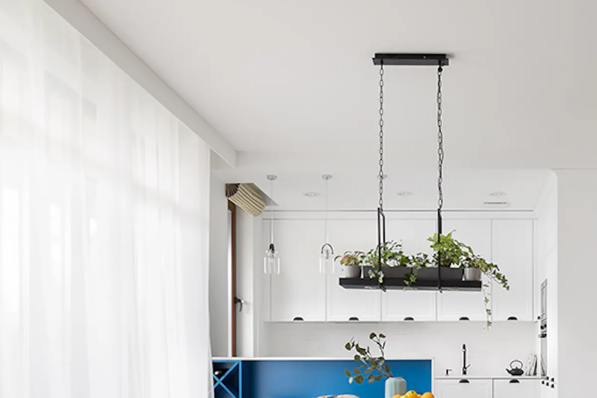 bright living room with dining table and open plan kitchen, white kitchen with breakfast bar worktop in blue white sliding door to utility room, wall photo gallery