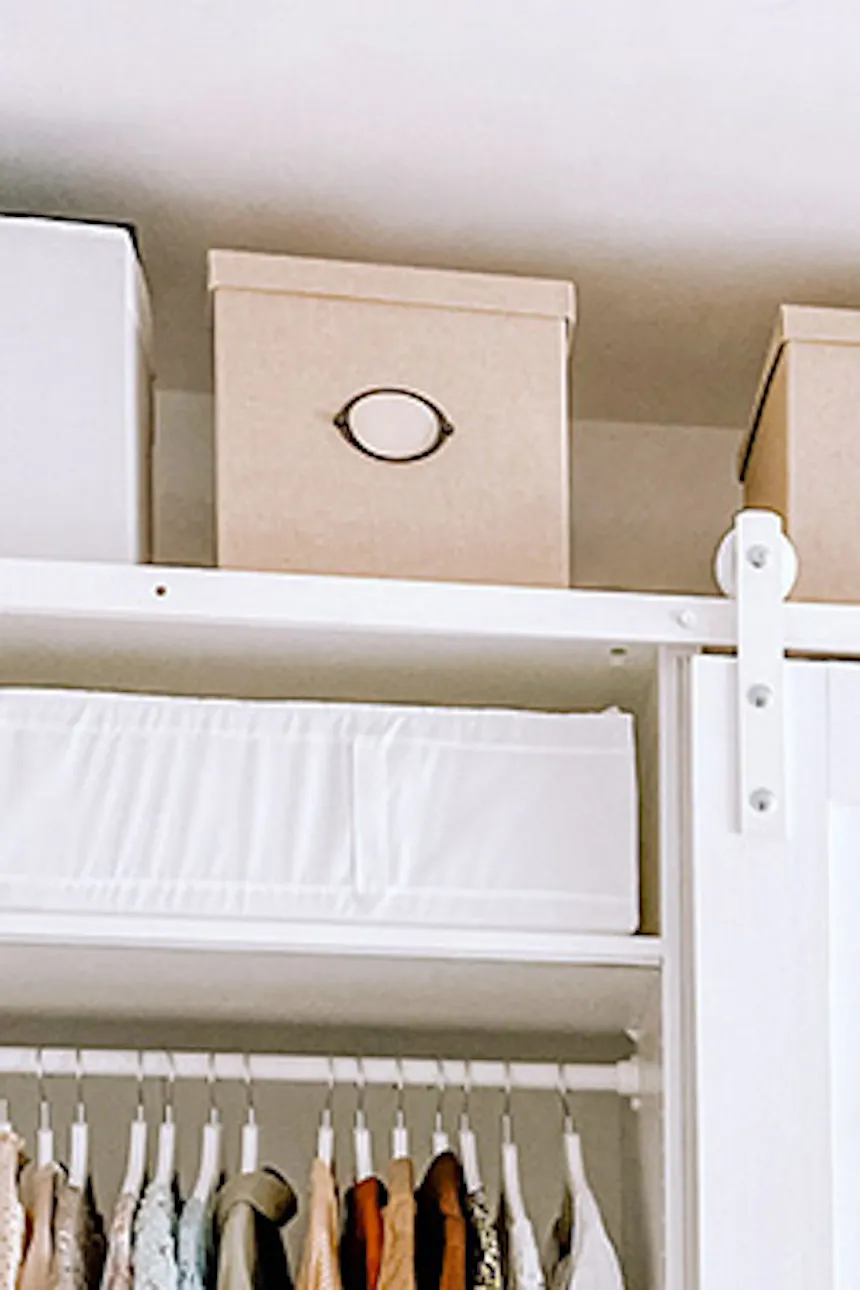 white wooden doors on white sliding system, white wardrobes, walk-in closet