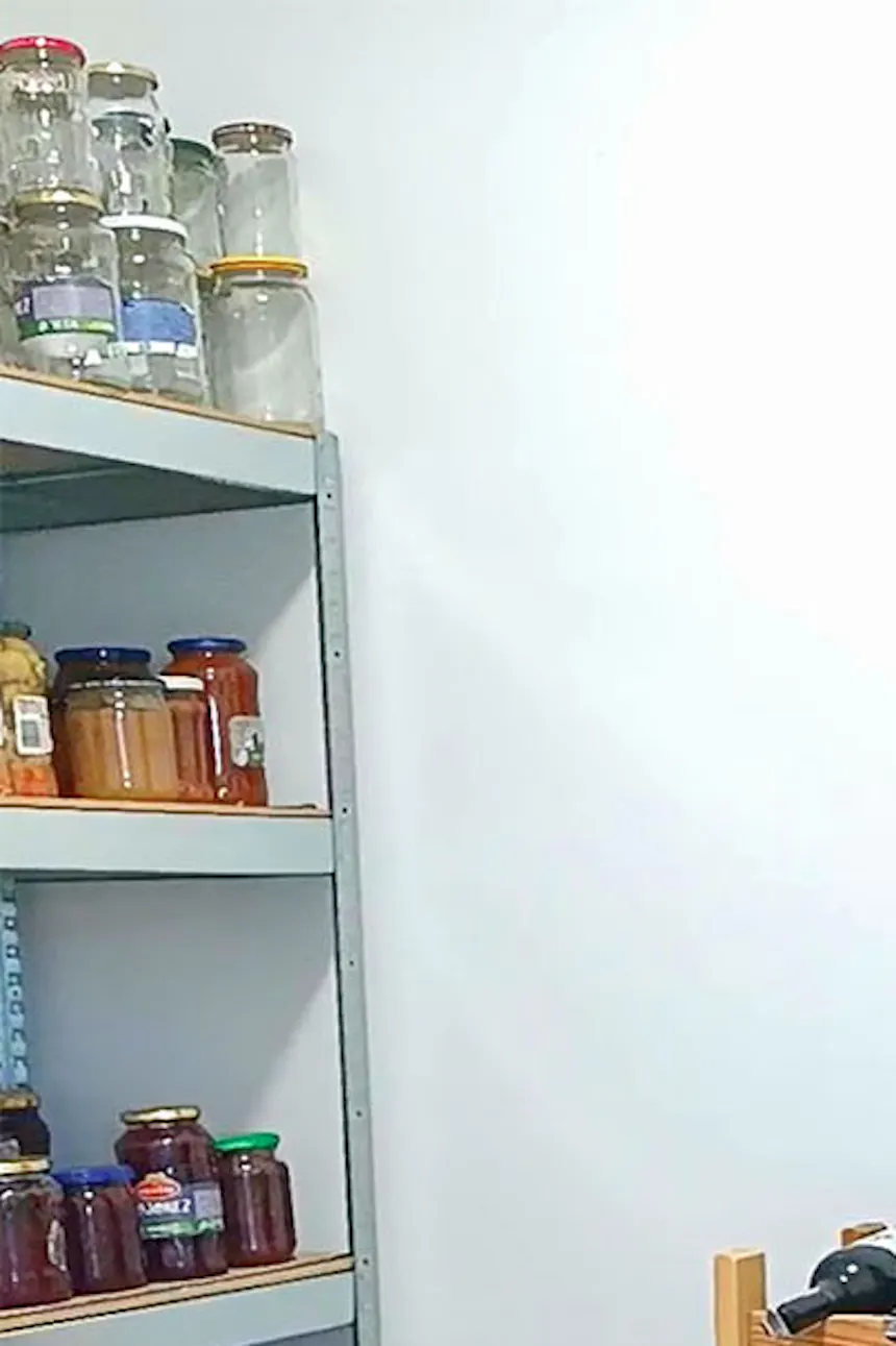 wooden shelves filled with preserves in a small pantry