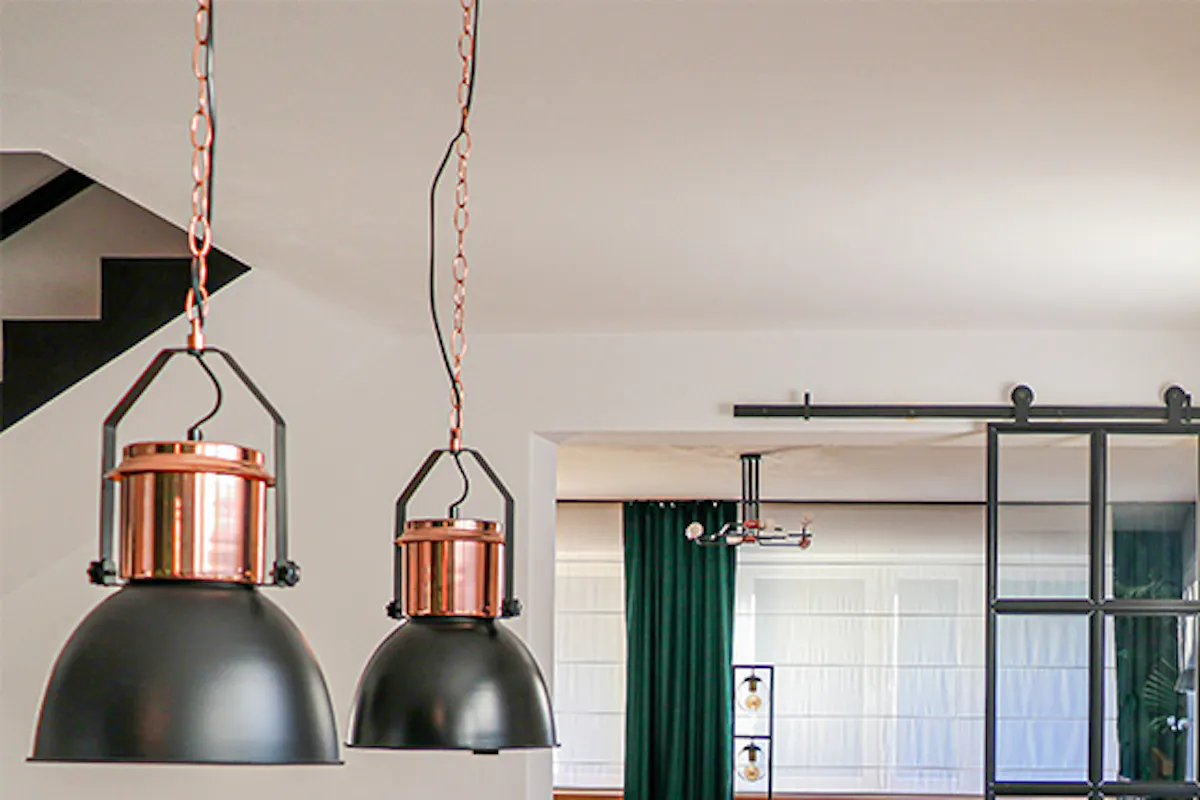 Black metal wall clock, industrial style clock, loft décor, metal glass door, loft door, metal glass sliding door, black glass door, green dining chairs, open living room to dining room, industrial pendant lights for dining room, large wooden dining table
