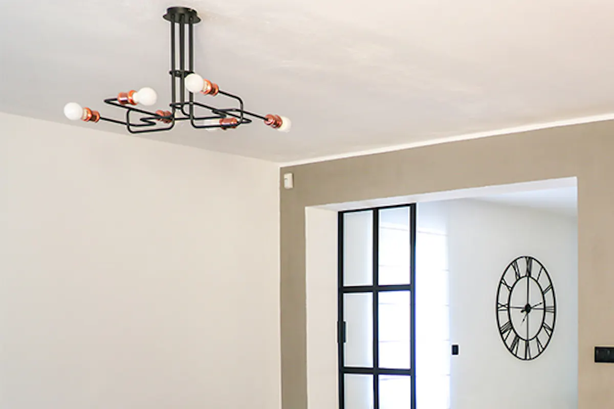 Open living room, gray sofa in living room, industrial lamp in living room, yellow armchair in living room, gray living room wall, living room open to dining room, metal glass door, glass sliding door, loft-style door, neon sign on wall, neon décor