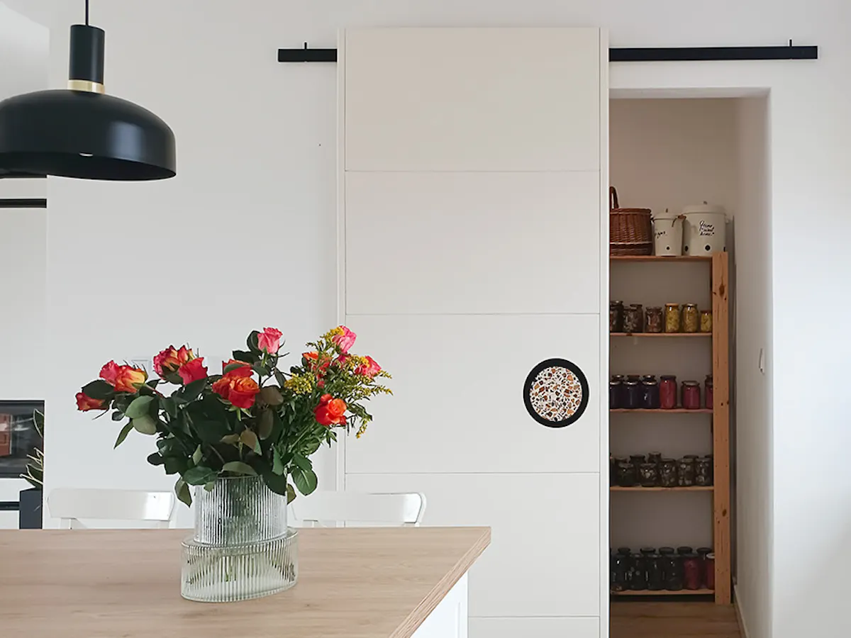 ouvrir la porte coulissante d'un garde-manger dans une cuisine blanche