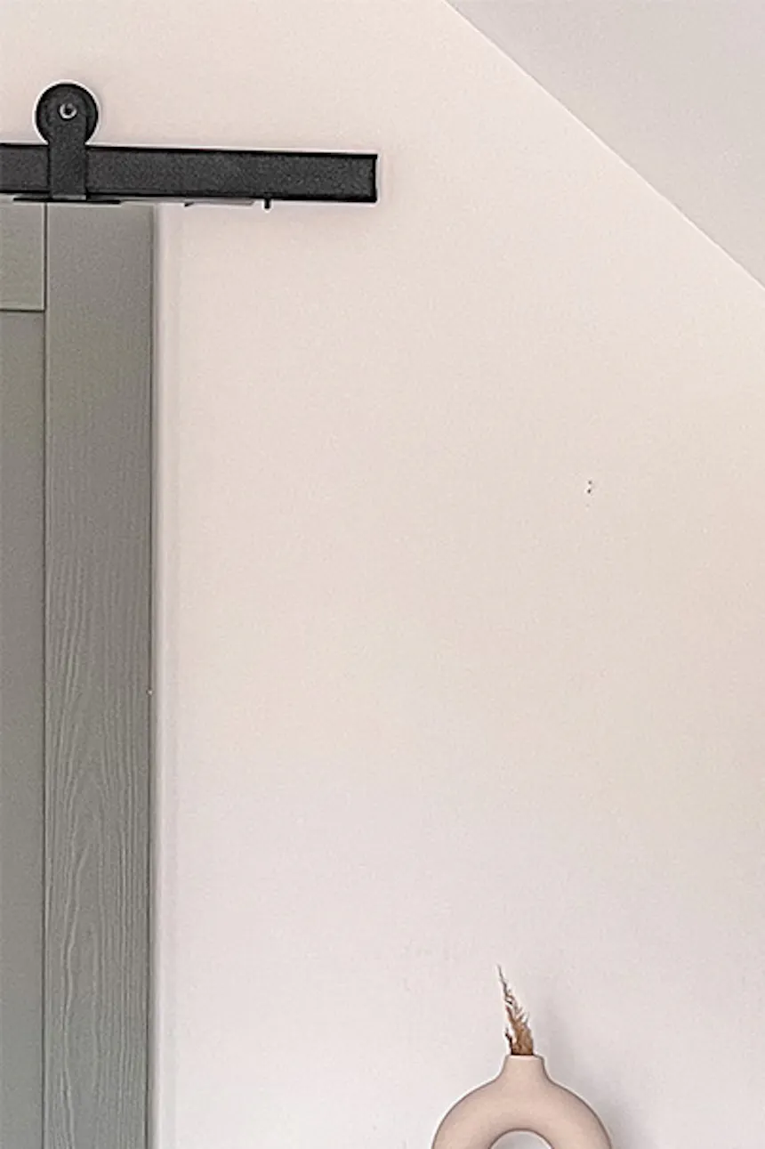 White Scandinavian-style dresser under a sloped ceiling