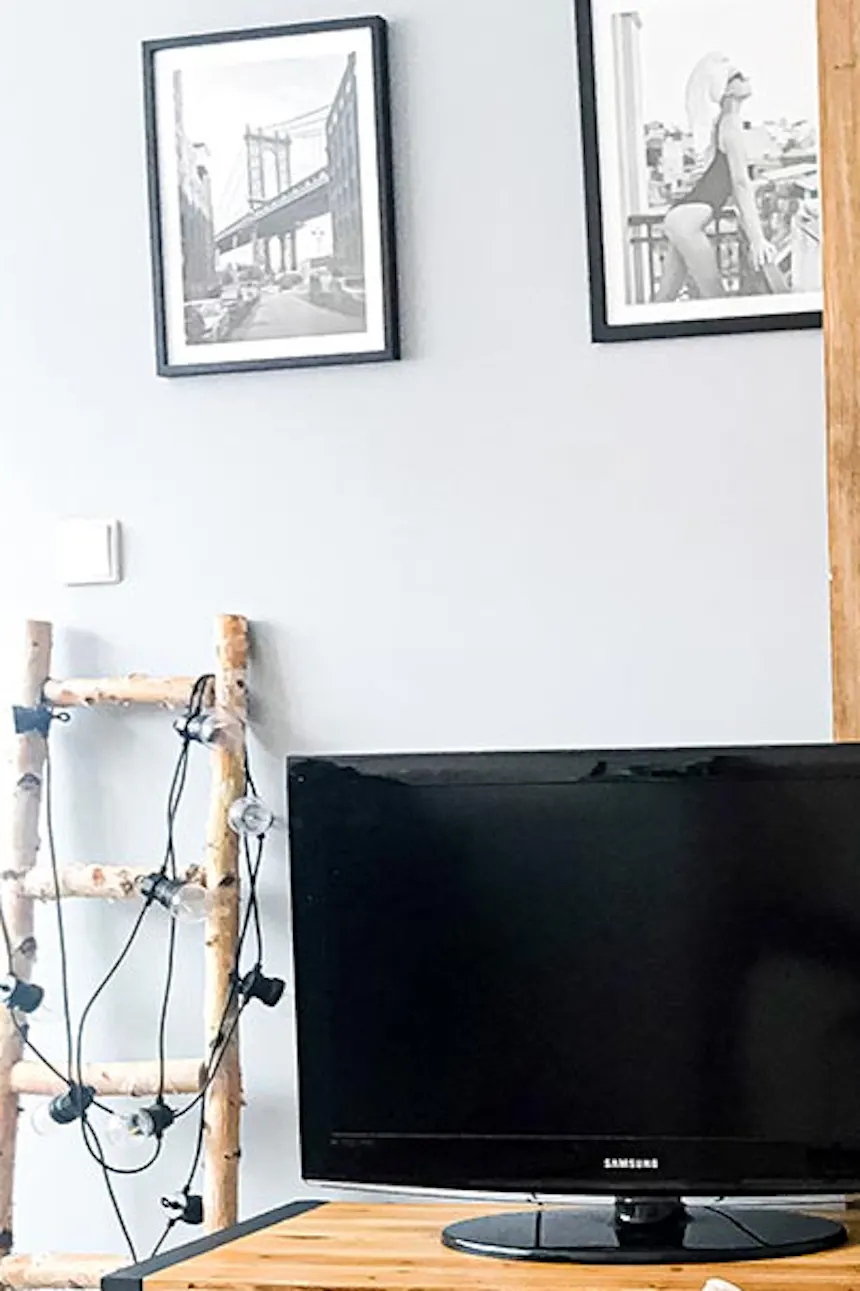 sliding doors in a small apartment, black metal coffee table, wooden sliding door with black handle, steel and wood TV cabinet, decorative candles and tulips on the coffee table