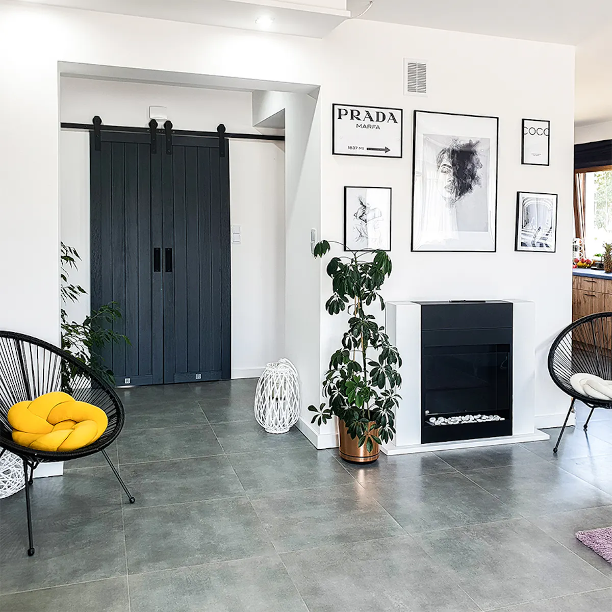 Anthracite room doors, double sliding doors, sliding doors in hallway, black interior accessories, photos in black frames, fireplace in living room, round openwork chair