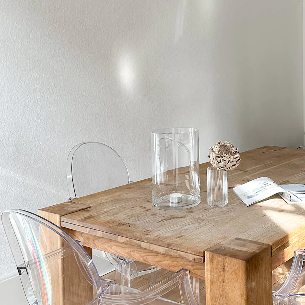 table massive en bois et chaises transparentes en plastique dans la cuisine
