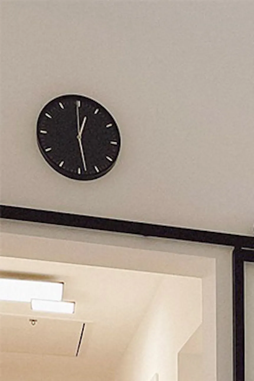 Glass sliding doors, metal door with clear glass, black and white open kitchen, black clock on white wall.