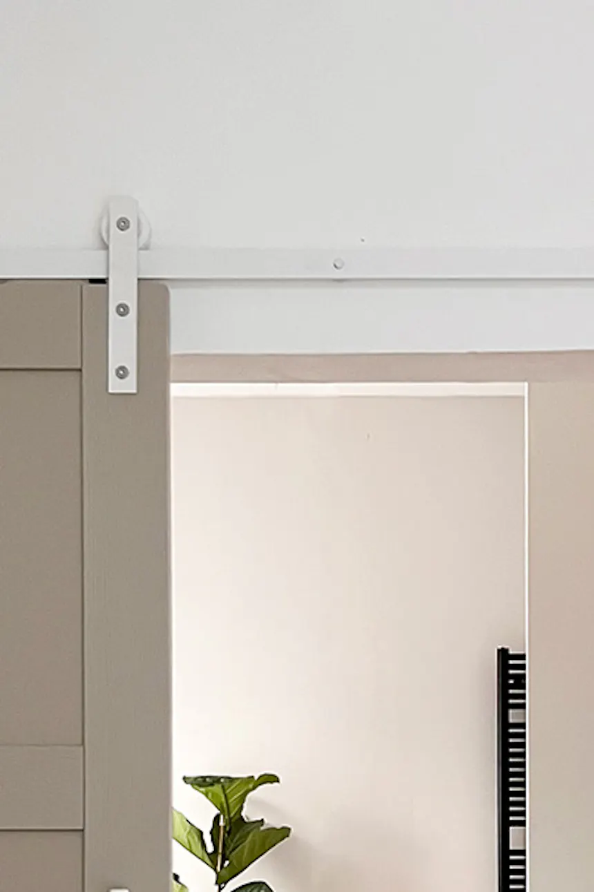 Bathroom entrance in gray and beige tones with black accessories