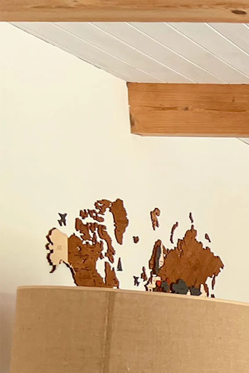 standing lamp with a jute shade standing next to a wooden chest of drawers in a black casing
