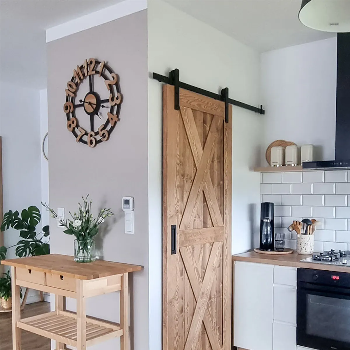wooden sliding doors closing a pantry in a kitchen decorated in a Scandinavian style with white cabinets and wooden accessories