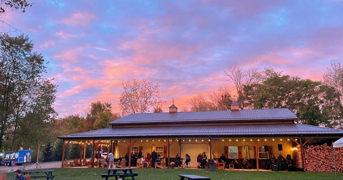 A picture of the Lost Trail Winery building with a pink and blue sunset sky above it.