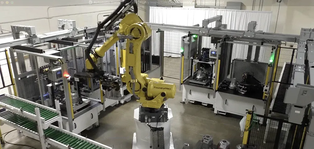 A yellow robot in an automotive manufacturing facility
